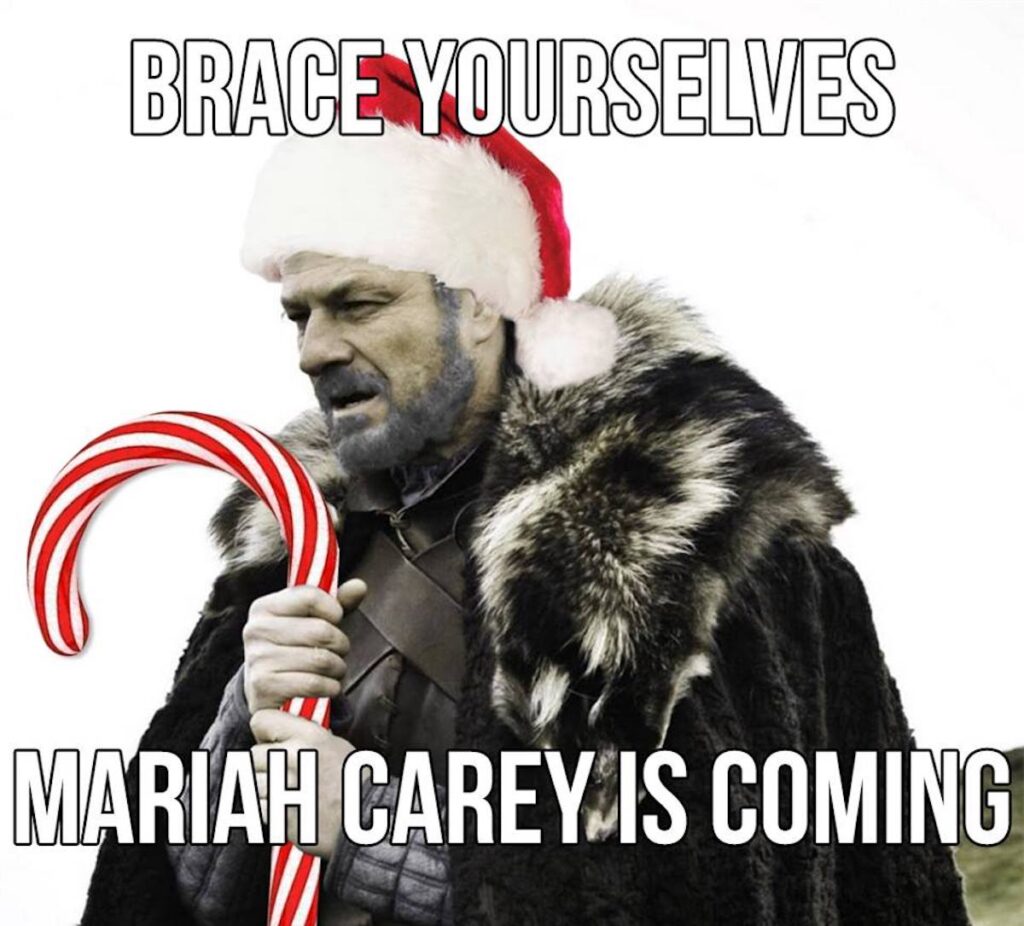 Game of Thrones "Winter is Coming" meme except he's holding a candy cane and wearing a Santa hat saying "Brace yourselves. Mariah Carey is coming."